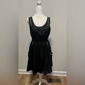 Black sleeveless dress with detailing of gold studs and pockets